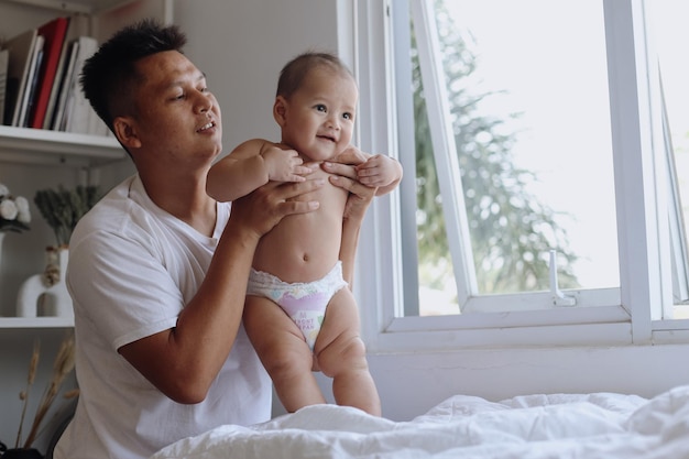 Happy father with adorable baby playing at home