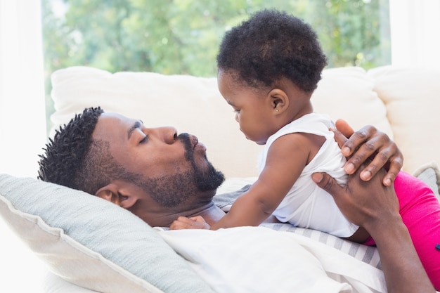 Happy father with baby girl on couch