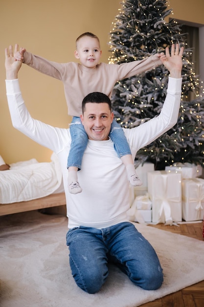 Happy father with his son playing home during winter holidays Christmas is coming