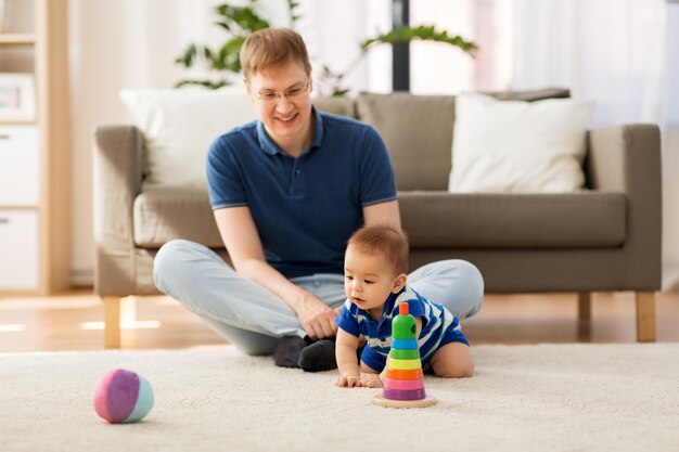 Photo happy father with little baby son playing at home