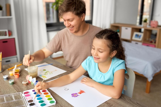 happy father with little daughter drawing at home