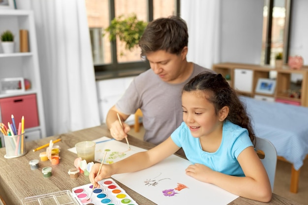 happy father with little daughter drawing at home