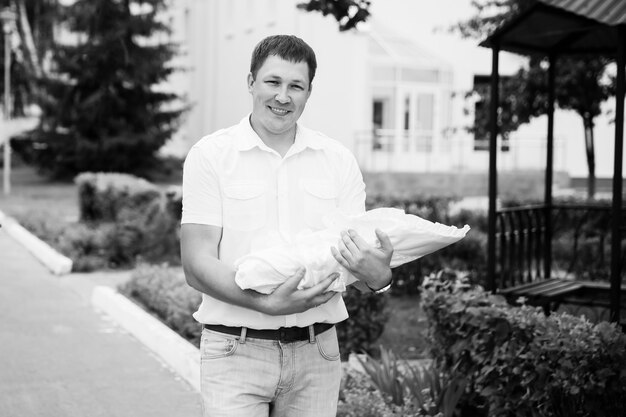 happy father with newborn baby standing near perinatal center.