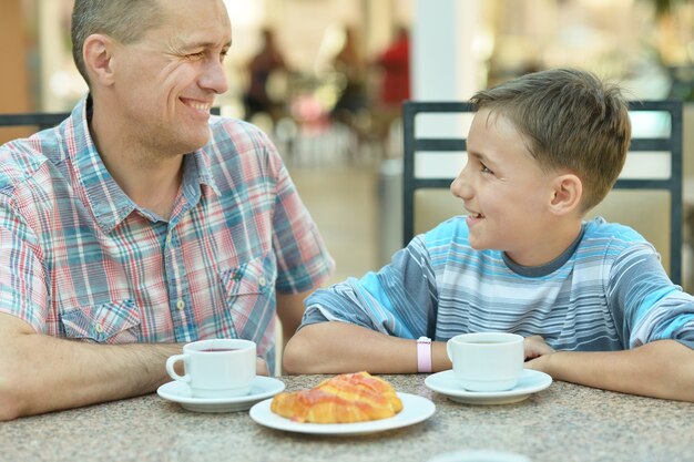 Happy father with son at breakfast on the table