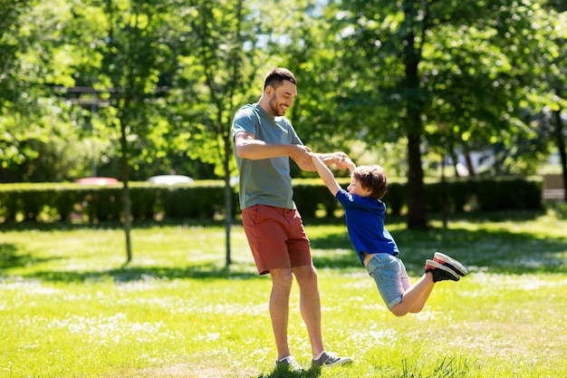 happy father with son playing in summer park