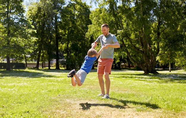 夏の公園で遊んでいる息子と幸せな父親