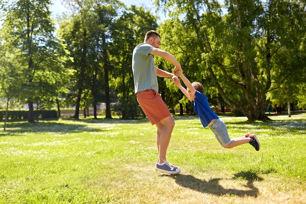 happy father with son playing in summer park