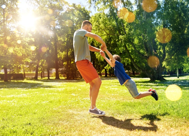 happy father with son playing in summer park