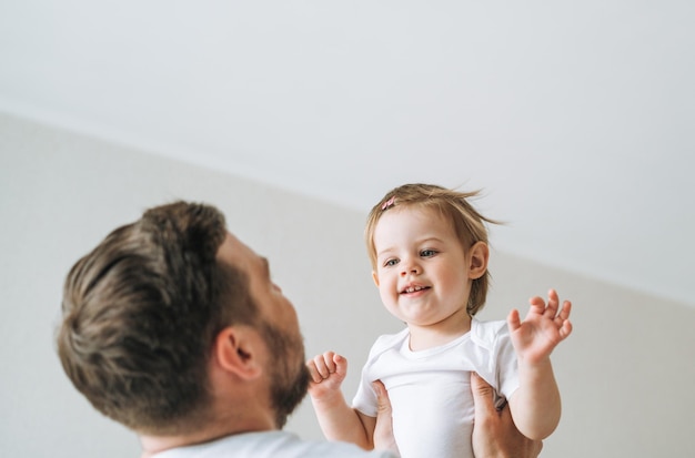 幸せな父親若い男と女の子小さな娘が家で子供の部屋で楽しんでいます