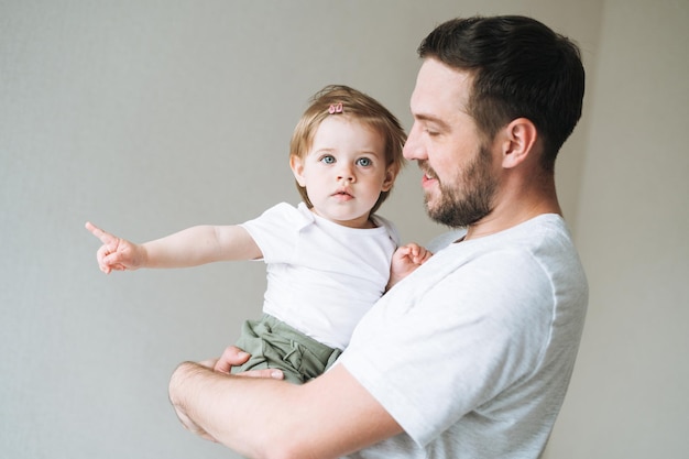 幸せな父親若い男と女の子小さな娘が家で子供の部屋で楽しんでいます