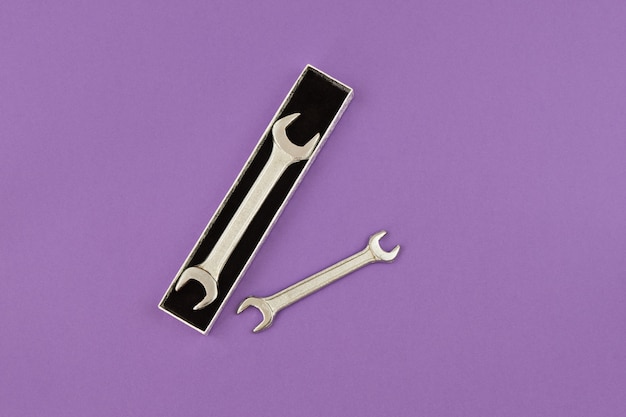 Happy Fathers Day flat lay. Wrench in gift box on purple