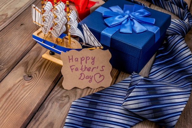 Happy Fathers Day geschenkdoos met stropdas op een rustieke houten achtergrond. Wenskaart