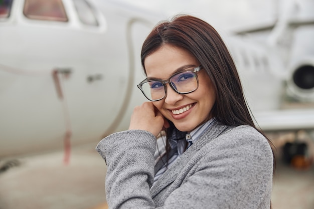Счастливая женщина бизнес-леди возле своего частного самолета