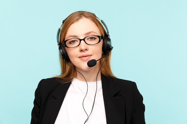 Operatore di call center femminile felice nello studio blu.