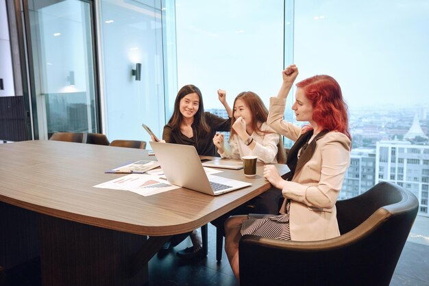 Happy female colleagues sitting in conference room at office