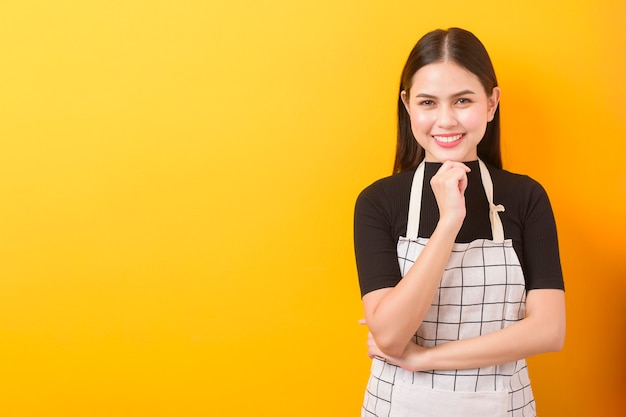 Happy female cook portrait on yellow background