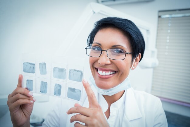 Happy female dentist holding x-ray