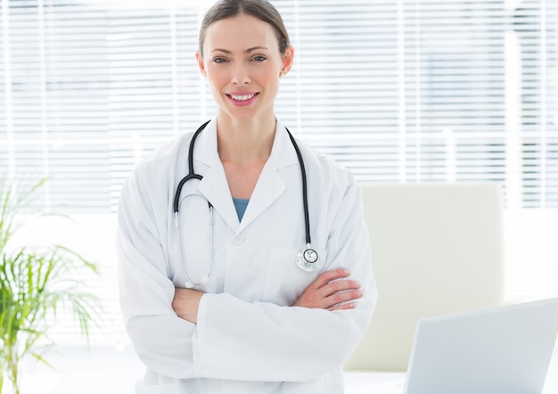 Happy female doctor with arms crossed