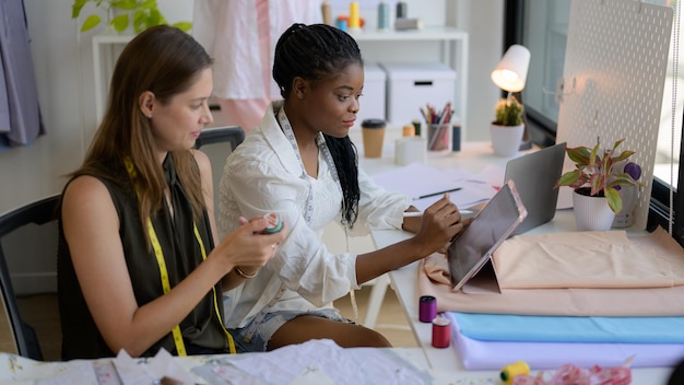 Photo happy female dressmaker working in workshop studio