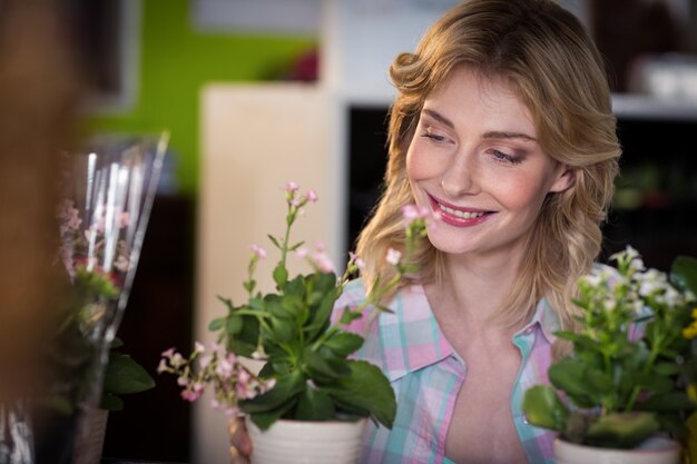 Happy female florist looking at flower pot