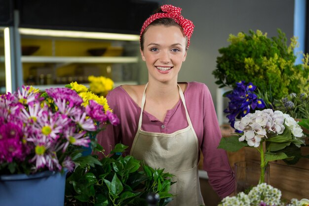 フラワーショップに立って幸せな女性の花屋