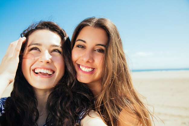 Photo happy female friends enjoying at beach during sunny day