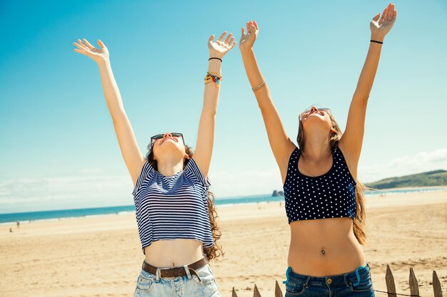 Photo happy female friends enjoying at beach during sunny day