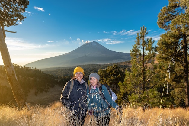 Happy female hikers with the popocatepetl volcano in the background