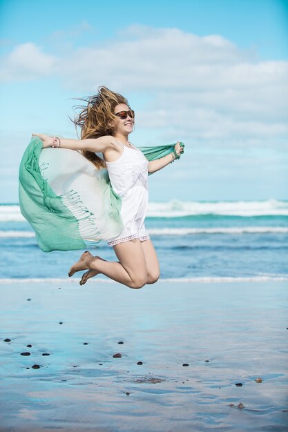 Happy female jumping on a beach