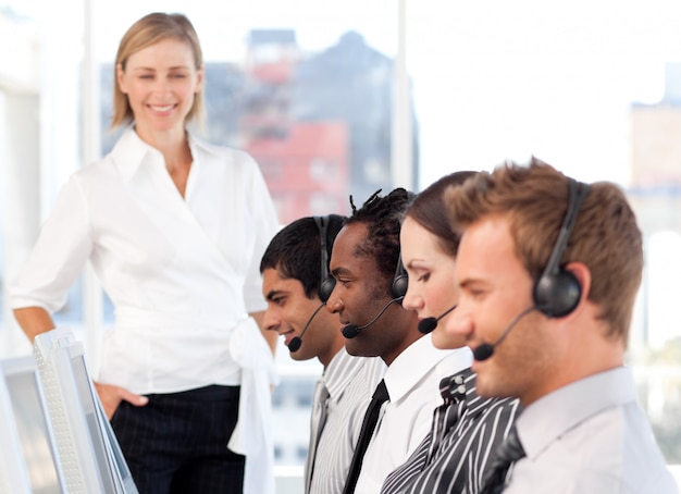 Happy female leader with her team on a call center