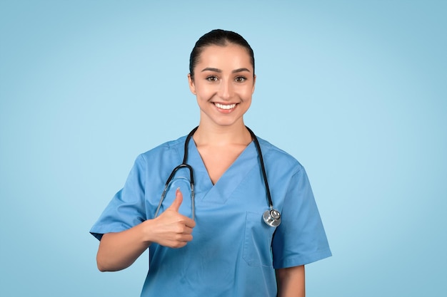 happy female nurse giving thumbs up and smiling