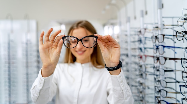 Happy female optometrist with set of glasses