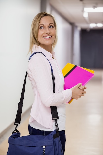 Happy female student walking in the hallway at the university