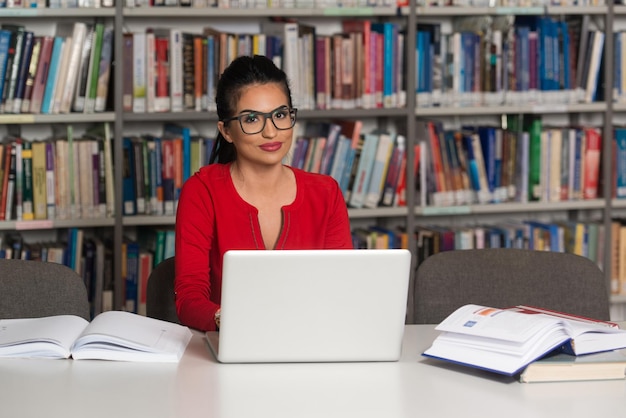 Happy Female Student With Laptop In Library