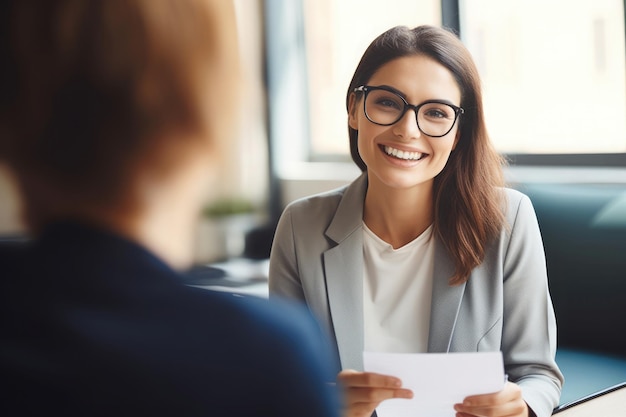 Foto donna felice con gli occhiali che sorride a un cliente in ufficio