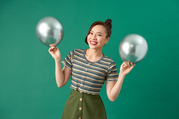 Happy female with smiling, having fun with two silver balloons.