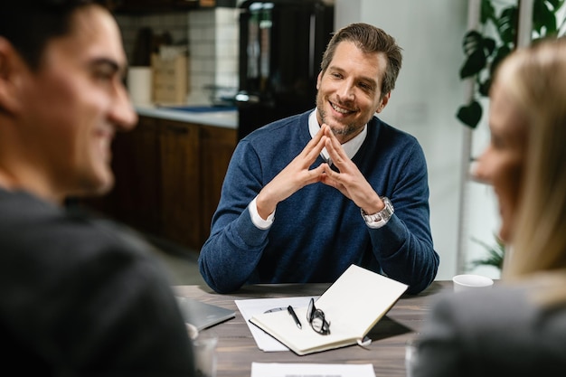 Happy financial advisor communicating with a couple about their home finances