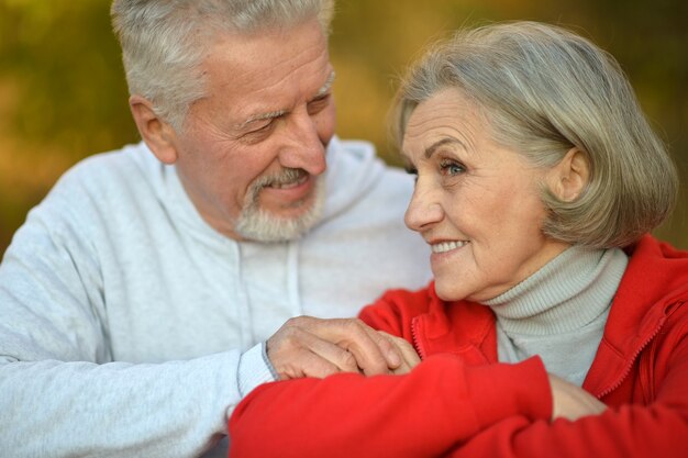 Happy fit senior couple  in autumn park