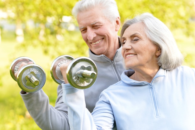 Happy fit senior couple exercising in  park