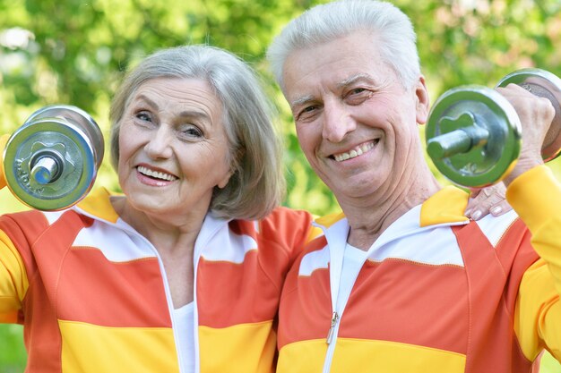 Happy fit senior couple exercising in  park