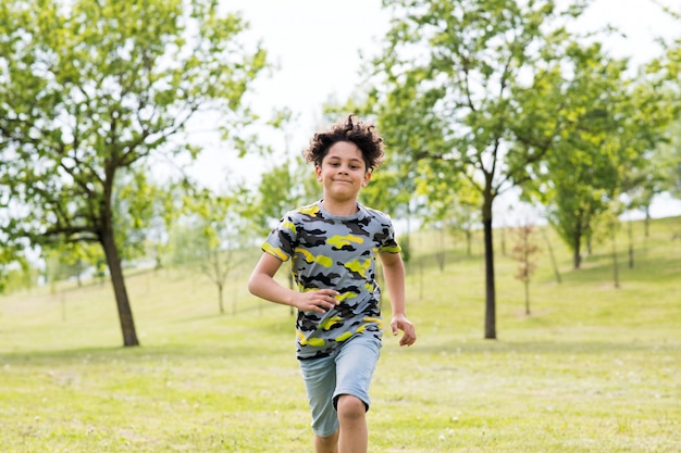 Happy fit young boy running towards the camera