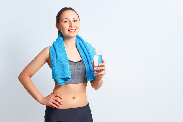 Happy fitness woman in sportswear with a towel