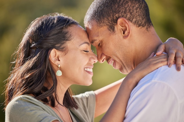 Happy forehead and couple with love smile bond and relax in romantic nature park date Peace freedom and beauty for man and woman on getaway to a green Spring forest woods or outdoor adventure