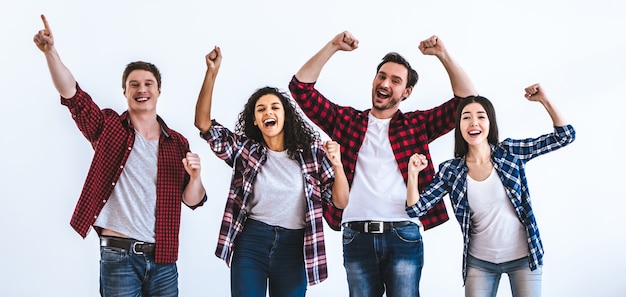 The happy four people gesturing on the white wall background