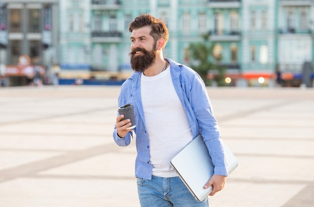 Happy freelancer man has online laptop communication outside freelancer man