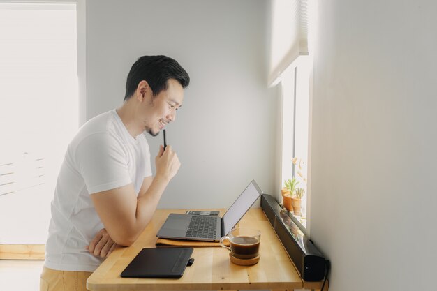 Photo happy freelancer man is working on his laptop. concept of freelance creative works.