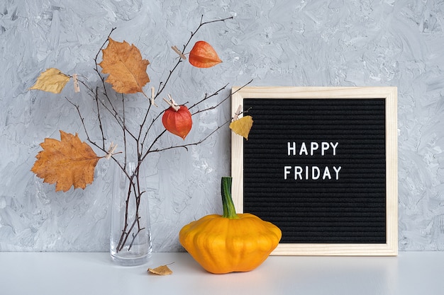 Happy Friday-tekst op zwart brievenbord en boeket van takken