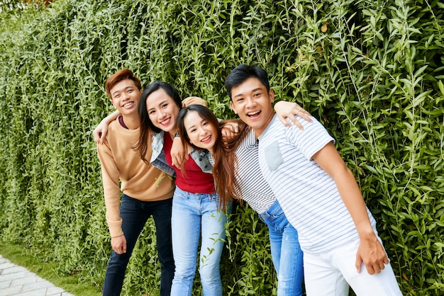 Happy friend posing near hedge