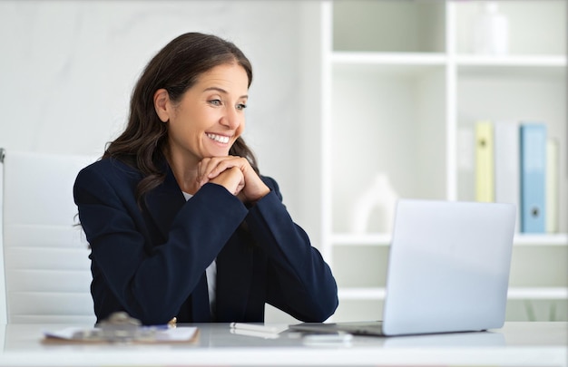 happy friendly mature woman s using laptop at office