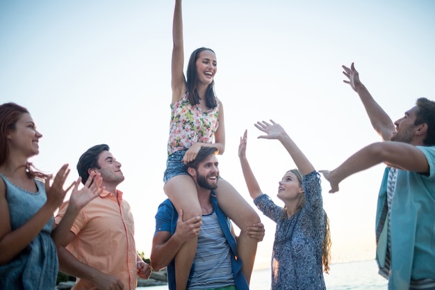 Happy friends dancing on the sand